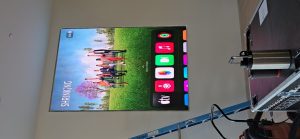 Large digital display showcasing a vibrant landscape with people and app icons, representing IT solutions and digital marketing services for Minding Your Media.