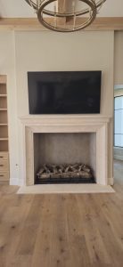 Modern fireplace with built-in television above, featuring a sleek design and light wood flooring, enhancing home aesthetics and comfort.