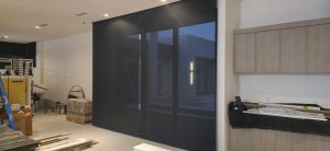 Interior space with modern sliding doors, construction materials and tools visible, emphasizing ongoing renovations for improved IT infrastructure and workspace efficiency.
